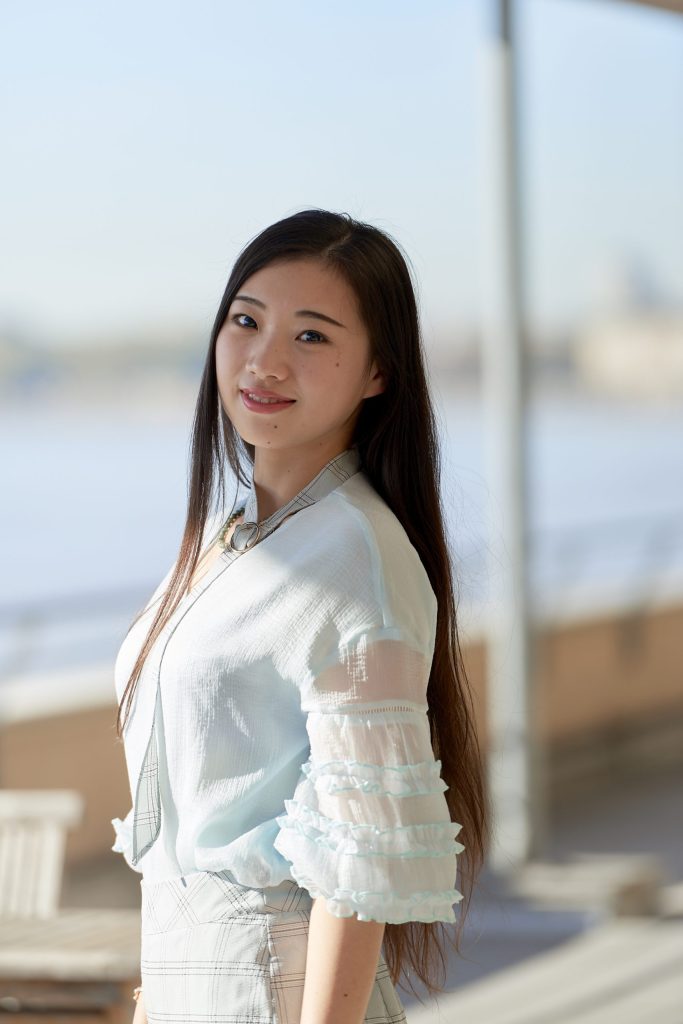 marketing student of Chinese nationality in front of the school